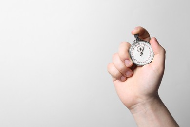 Man holding vintage timer on white background, closeup. Space for text