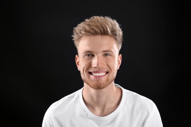 Photo of Portrait of handsome young man on black background