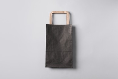 Black paper bag on light grey background, top view