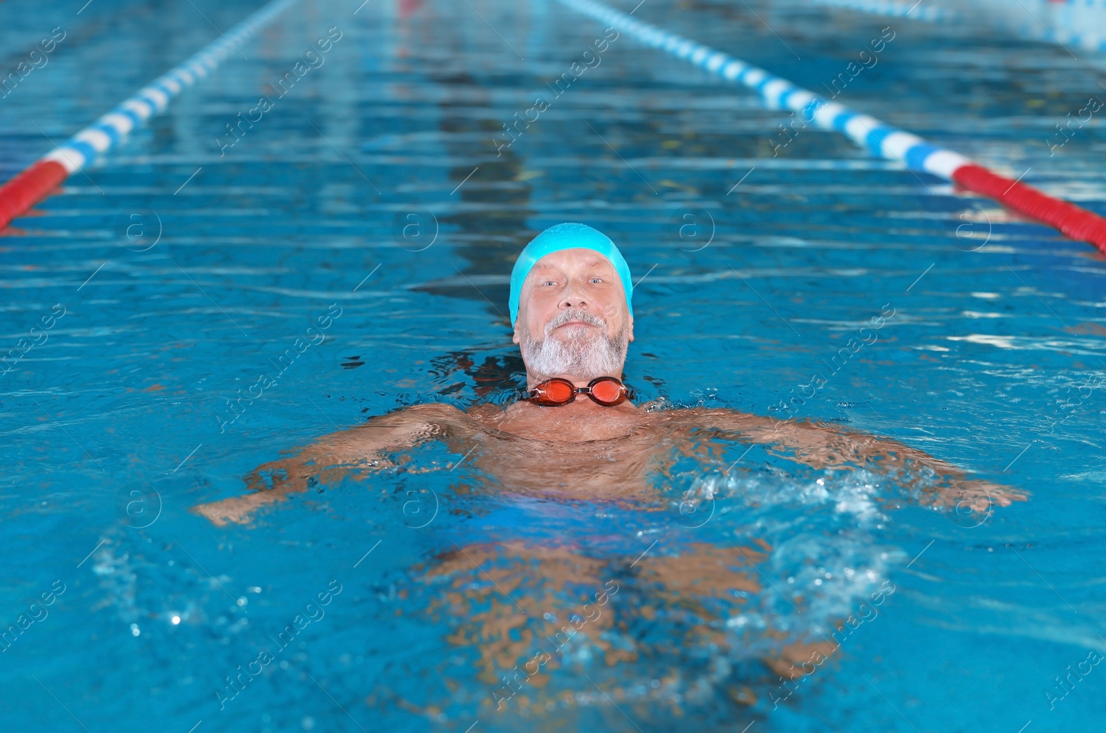 Photo of Sportive senior man in indoor swimming pool