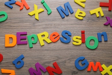 Word Depression made of colorful letters on wooden table, flat lay