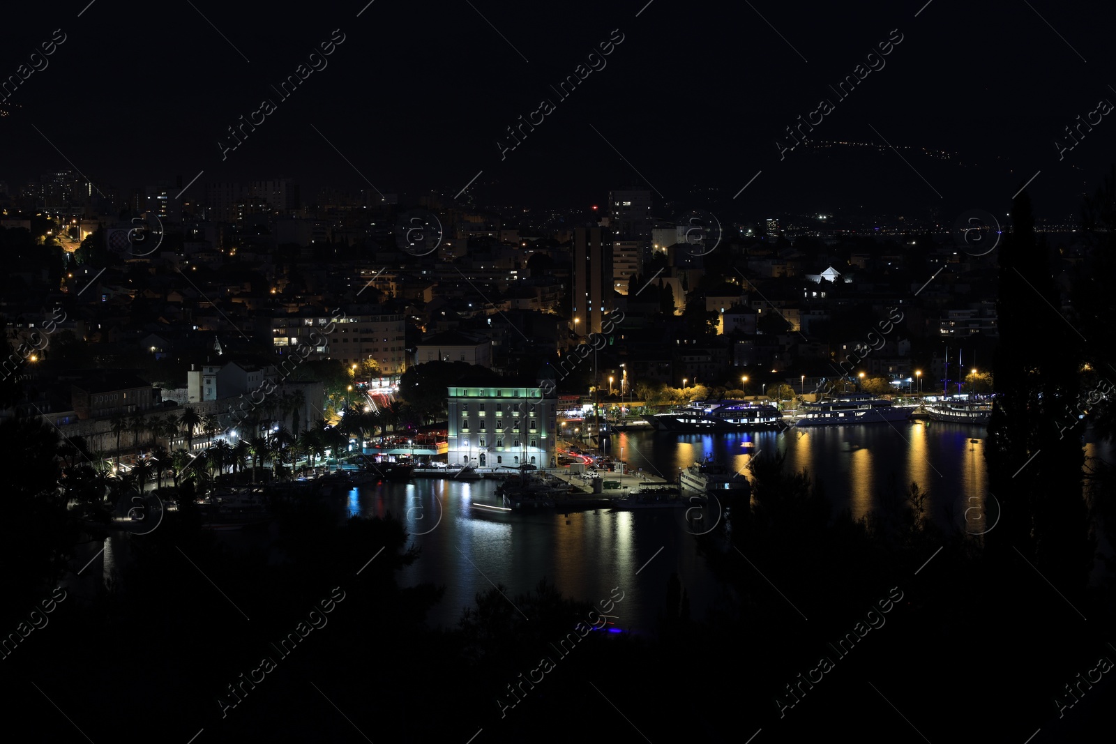 Photo of SPLIT, CROATIA - OCTOBER 08, 2023: Beautiful view of illuminated city with port and buildings at night