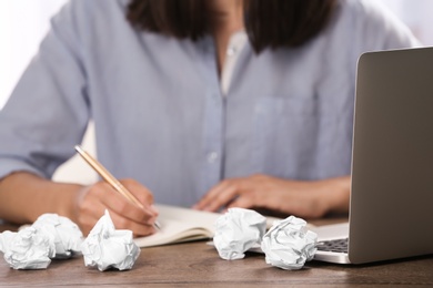 Photo of Woman working at table with crumpled paper, closeup. Generating idea