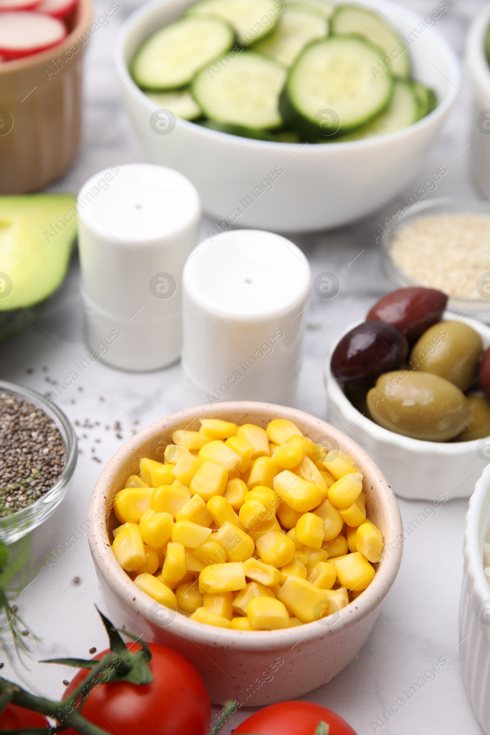 Photo of Ingredients for poke bowl on white marble table