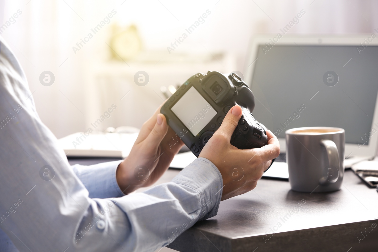 Image of Journalist with camera at table in office, closeup