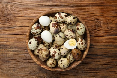 Photo of Unpeeled and peeled hard boiled quail eggs in bowl on wooden table, top view