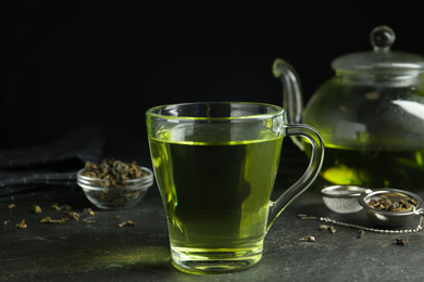 Cup of aromatic green tea on grey table