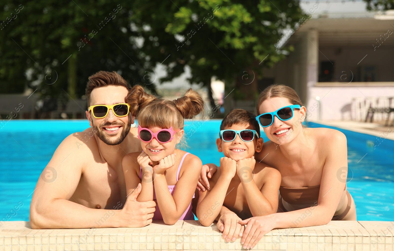 Photo of Happy family in swimming pool on sunny day