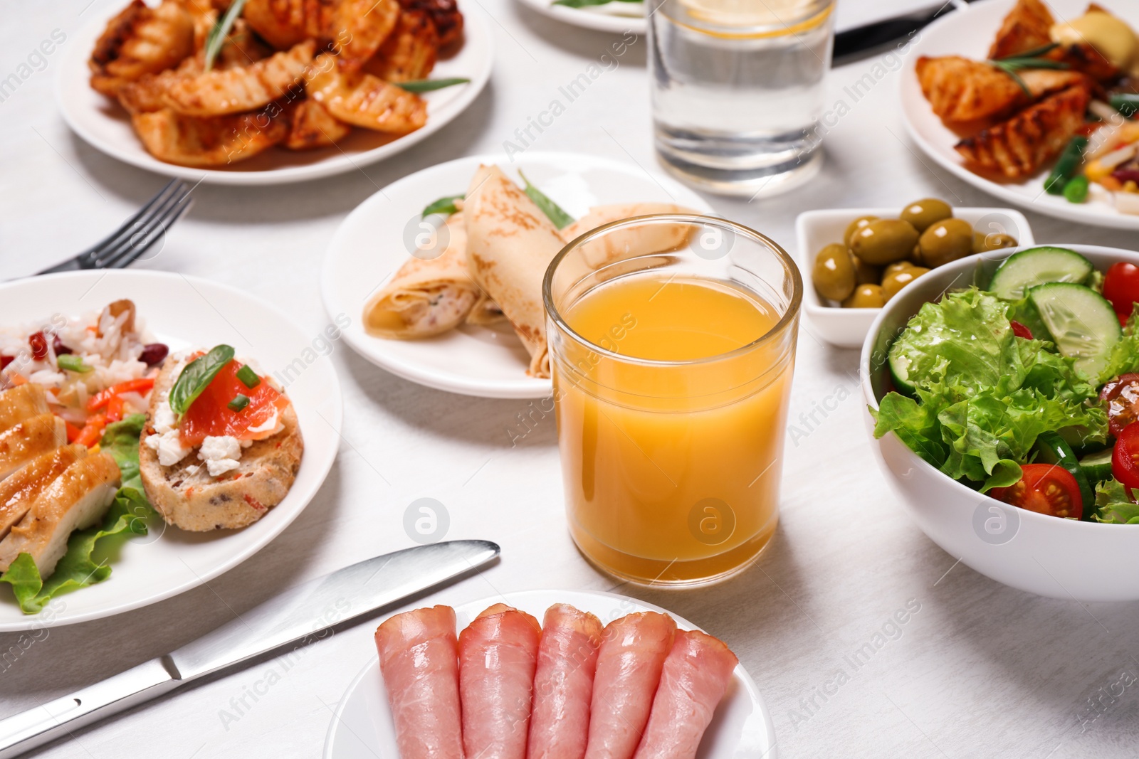 Photo of Buffet service. Many different dishes on white wooden table