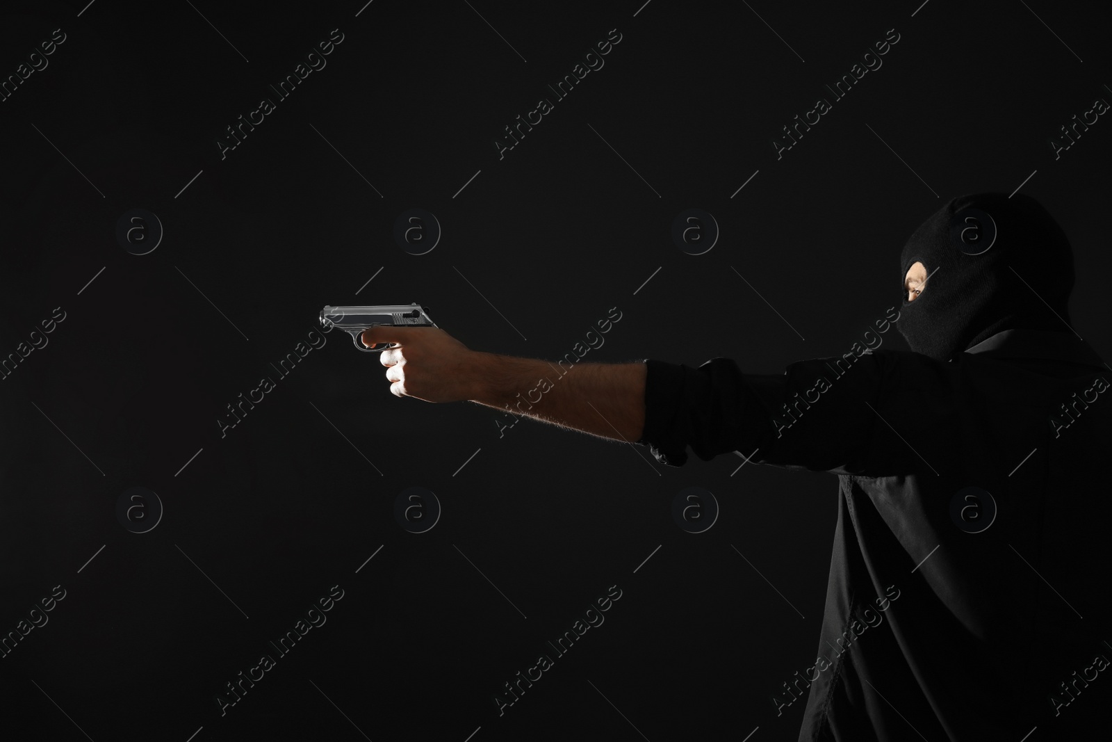 Photo of Professional killer with gun on black background