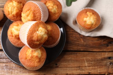 Delicious sweet muffins on wooden table, flat lay. Space for text