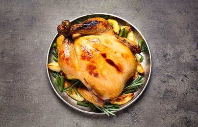 Photo of Delicious cooked turkey with garnish on grey table, top view. Thanksgiving Day celebration