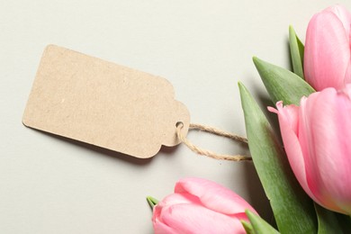 Happy Mother's Day. Beautiful flowers with blank card on light background, flat lay