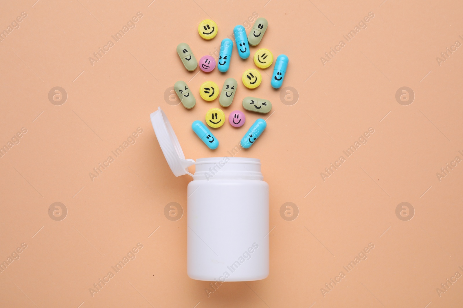 Photo of Bottle and antidepressant pills with funny faces on pale orange background, flat lay