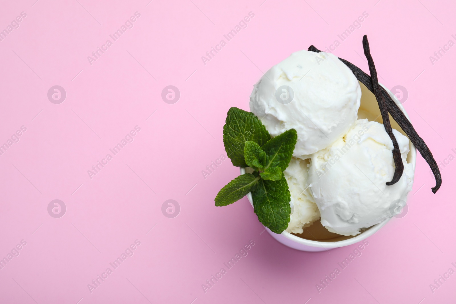 Photo of Delicious vanilla ice cream on pink background, top view. Space for text