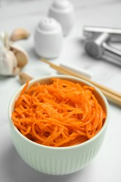 Photo of Delicious Korean carrot salad in bowl on white table