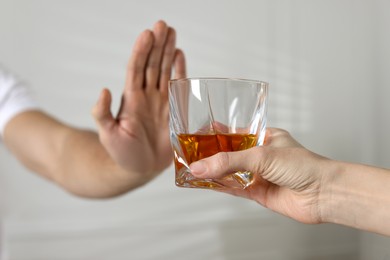 Photo of Man refusing to drink whiskey indoors, closeup. Alcohol addiction treatment