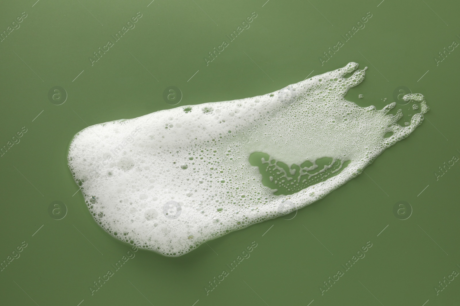 Photo of Smudge of white washing foam on olive background, top view