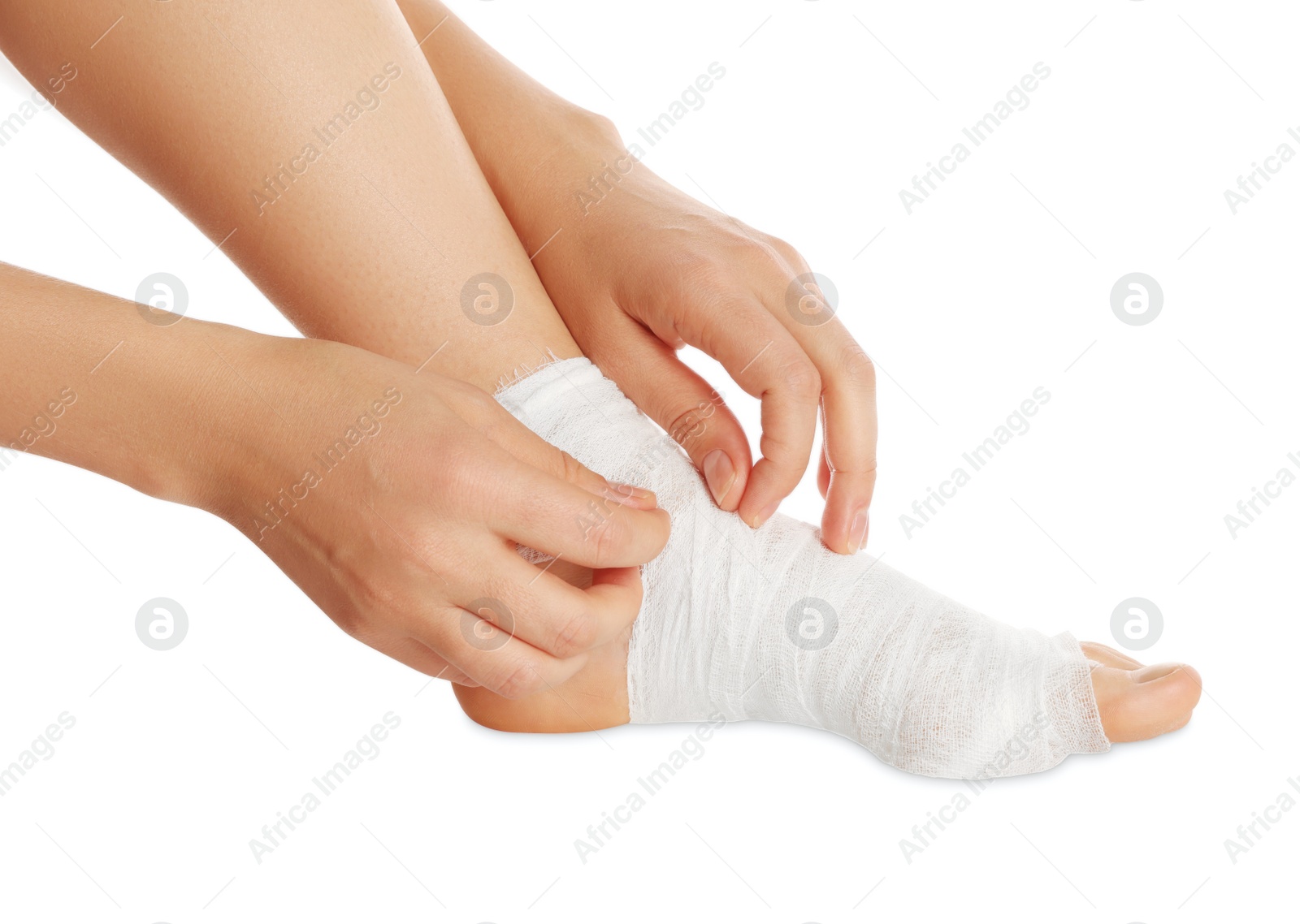 Photo of Woman wrapping foot in medical bandage on white background, closeup