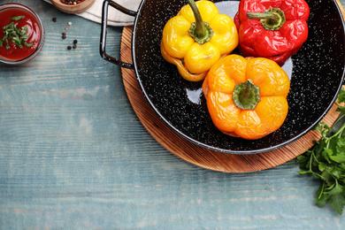 Photo of Tasty stuffed bell peppers on blue wooden table, flat lay