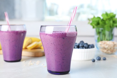 Glasses of delicious blueberry smoothie served on kitchen table