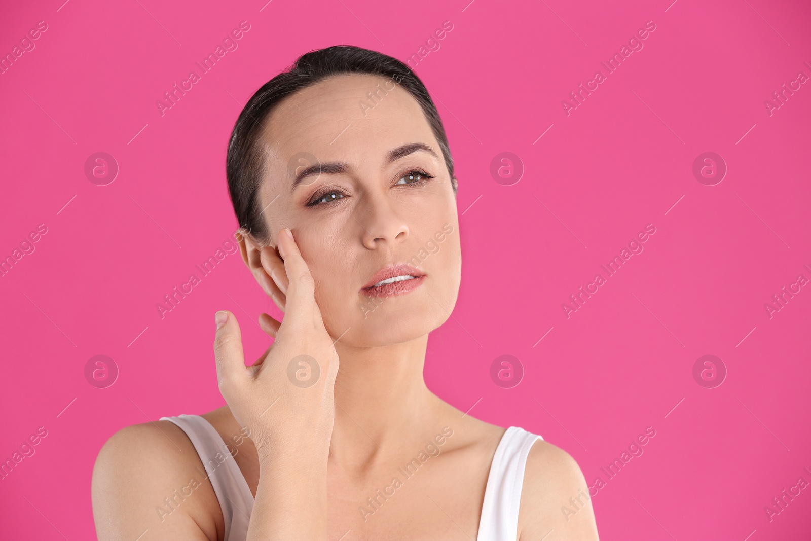 Photo of Portrait of beautiful mature woman on pink background