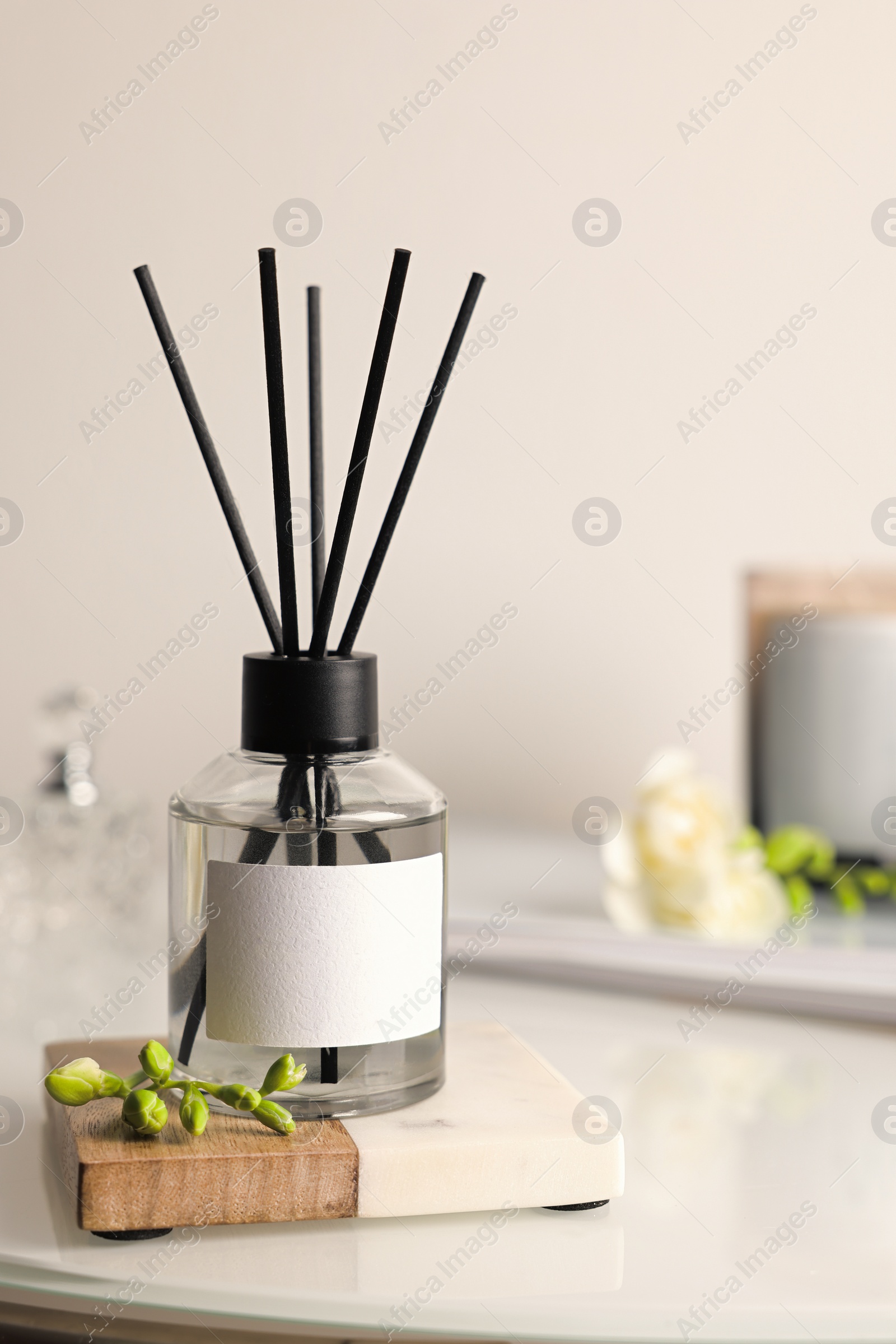 Photo of Aromatic reed air freshener on white table, space for text