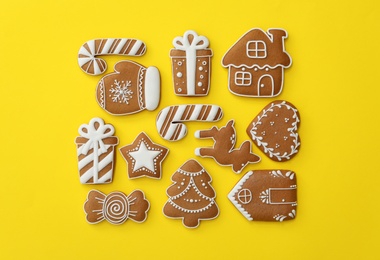 Photo of Different Christmas gingerbread cookies on yellow background, flat lay