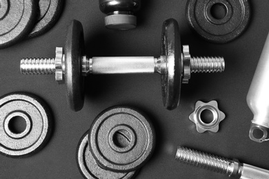 Photo of Flat lay composition with dumbbell and parts on dark background