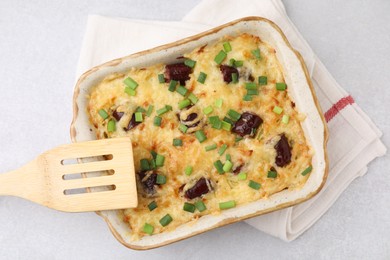 Tasty sausage casserole with green onions in baking dish on white table, top view