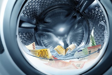 Image of Money laundering. Many euro banknotes in washing machine