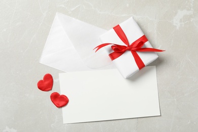 Photo of Flat lay composition with blank card on light background, space for text. Valentine's Day celebration