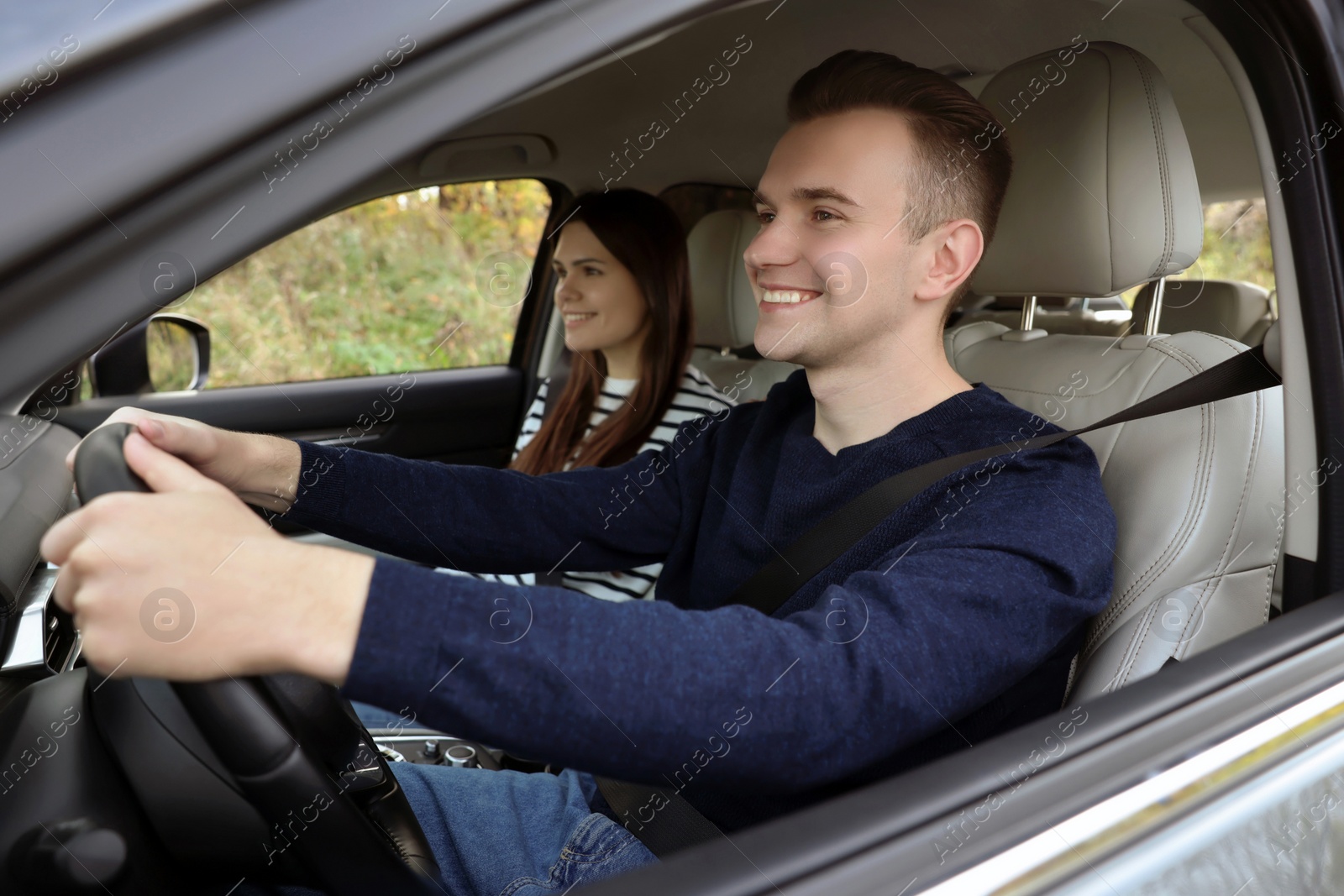 Photo of Happy young couple travelling together by car