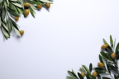 Photo of Fresh green olives and leaves on white background, flat lay. Space for text