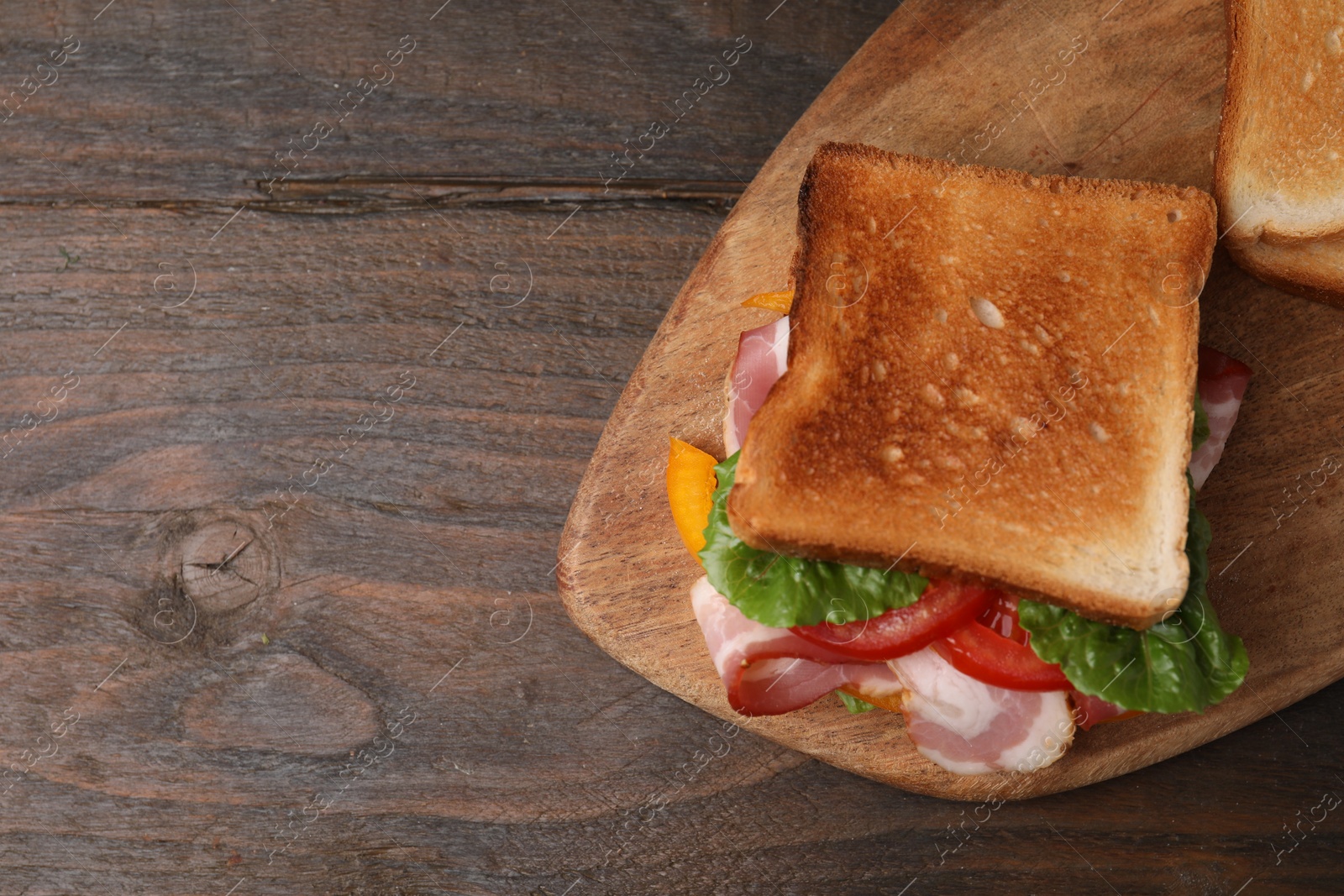 Photo of Tasty sandwiches with bacon and tomato on wooden table, top view. Space for text