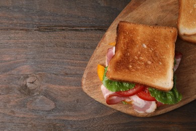 Tasty sandwiches with bacon and tomato on wooden table, top view. Space for text