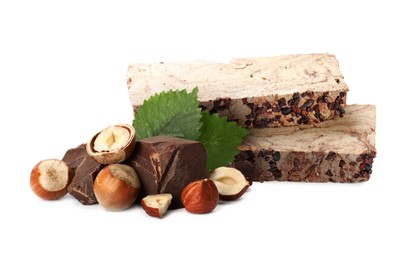 Image of Tasty halva, pieces of chocolate, hazelnuts and green leaves isolated on white