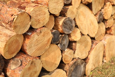 Photo of Stacked firewood outdoors, closeup. Heating in winter