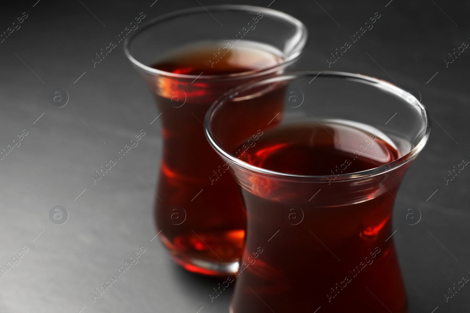 Photo of Glasses with traditional Turkish tea on black table, closeup