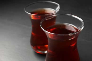 Glasses with traditional Turkish tea on black table, closeup