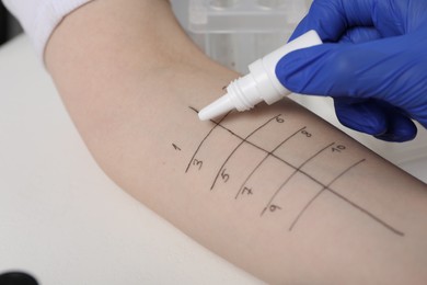 Doctor doing skin allergy test at light table, closeup