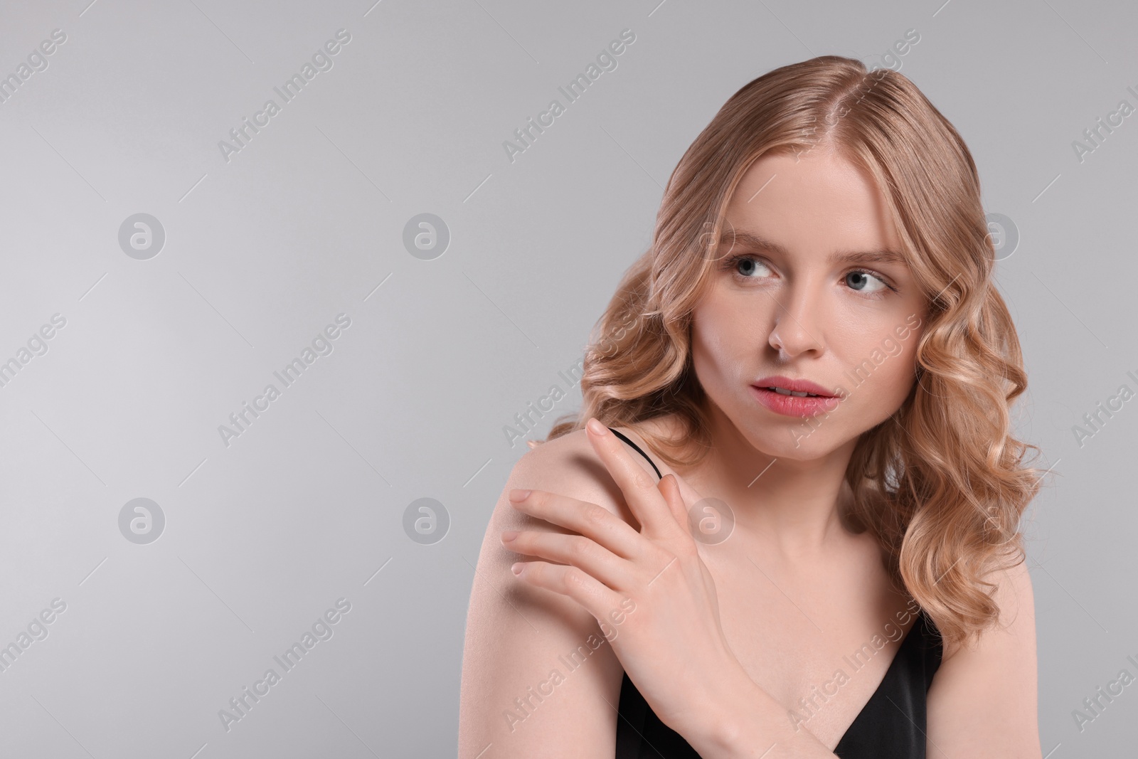 Photo of Portrait of beautiful woman with blonde hair on light grey background. Space for text