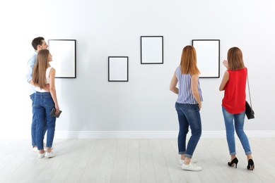 Photo of People viewing exposition in modern art gallery