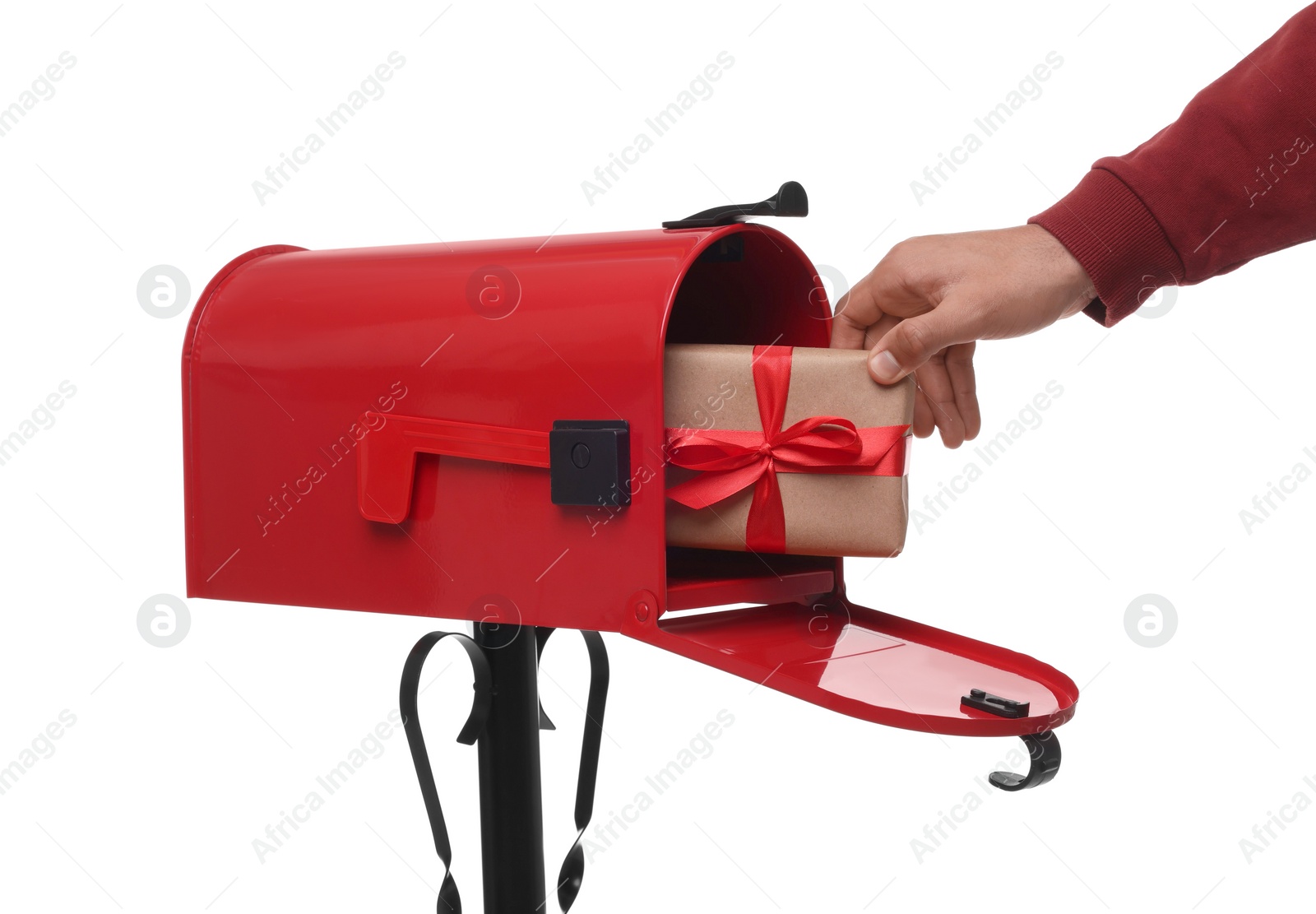 Photo of Man putting Christmas gift into mailbox on white background, closeup. Sending present by mail