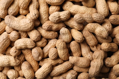 Photo of Dry peanuts in shell as background, top view. Healthy snack