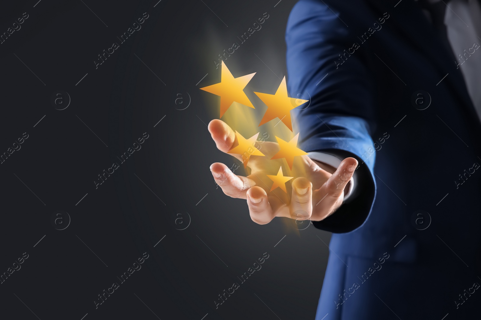 Image of Man holding virtual stars on black background, closeup. Customer satisfaction score