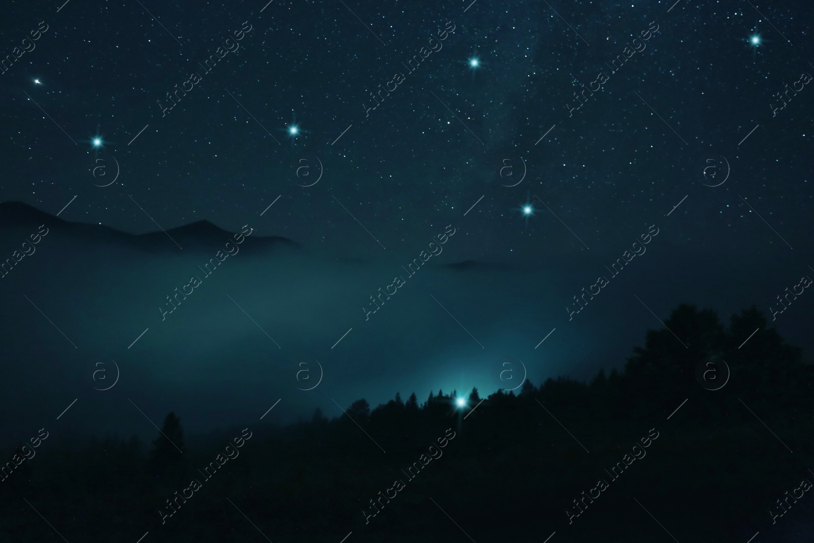 Image of Foggy hill under starry sky at night