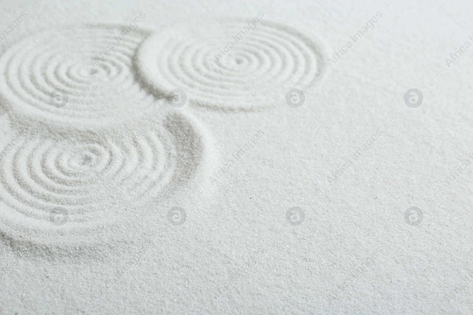 Photo of Zen rock garden. Circle patterns on white sand, closeup. Space for text