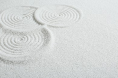 Photo of Zen rock garden. Circle patterns on white sand, closeup. Space for text