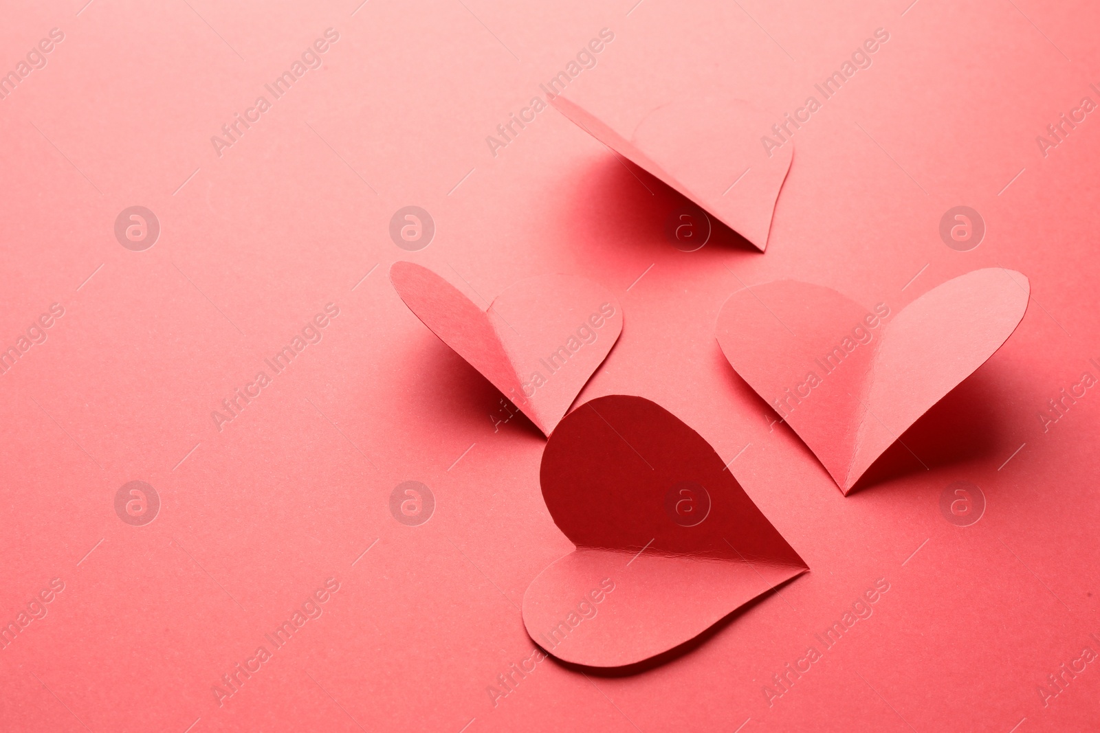 Photo of Paper hearts on red background, closeup. Space for text